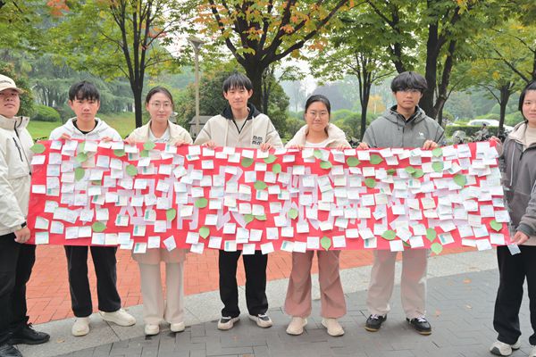图三 工作人员举着贴满便签的横幅合影.JPG
